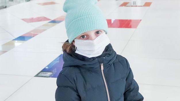 Garotinho, a criança está vestindo um casaco e chapéu. máscara facial para proteção contra surtos de coronavírus. novo coronavírus 2019-ncov da china. máscara higiênica facial para segurança, vírus e gripe