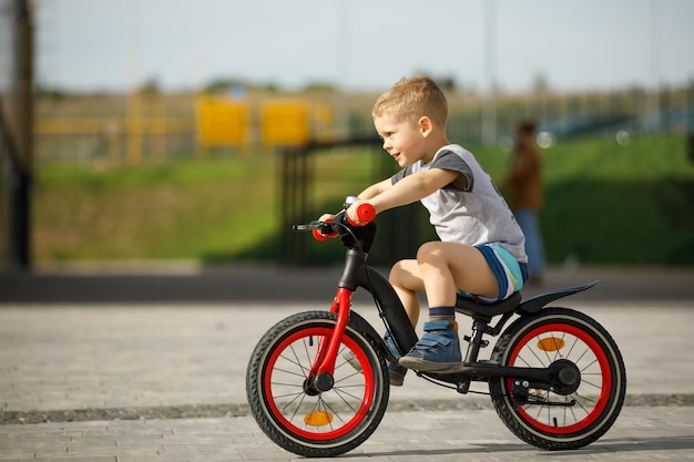 Garotinho andando de bicicleta em um parque da cidade