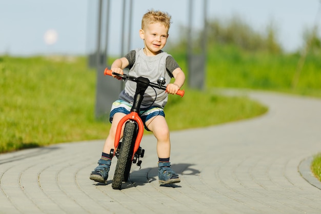 Garotinho andando de bicicleta em um parque da cidade