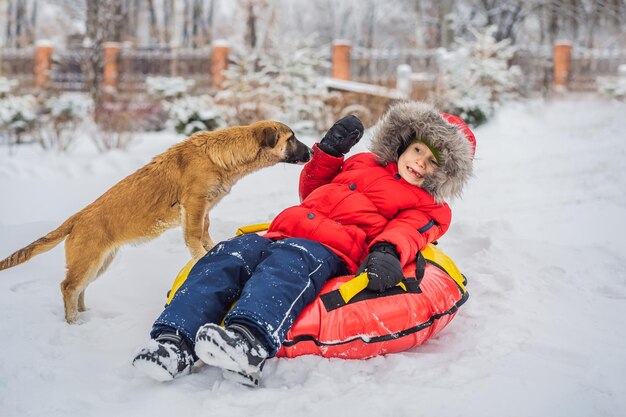 Garotinho brinca com um cachorrinho no inverno