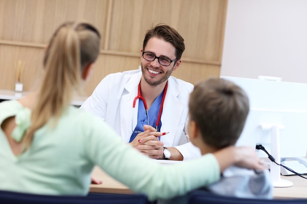 garotinho com a mãe na clínica sendo examinado pelo pediatra