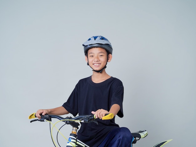 Garotinho com bicicleta na luz de fundo