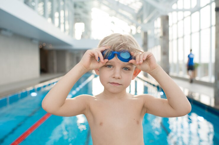 Foto garotinho com googles em uma piscina