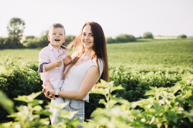 Garotinho com sua mãe em um campo verde