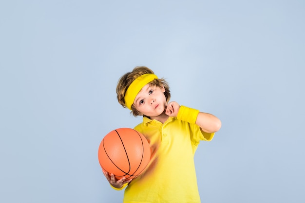 Garotinho com uniforme esportivo jogando basquete pequeno jogador de basquete com roupa esportiva segurando a bola