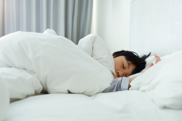 Garotinho, dormindo na cama no quarto