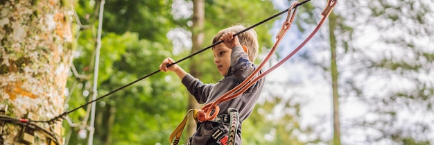Garotinho em um parque de cordas recreação física ativa da criança ao ar livre no parque