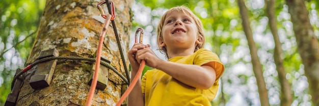 Garotinho em um parque de cordas recreação física ativa da criança ao ar livre no parque