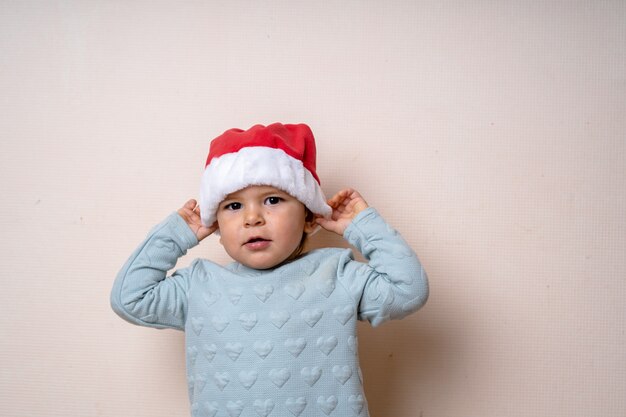 Garotinho engraçado no chapéu vermelho Papai Noel.