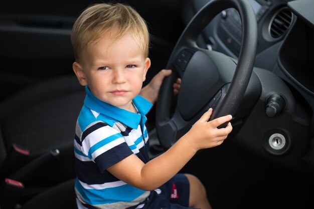 Garotinho fofo dirigindo o carro do pai