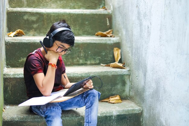 Garotinho indiano estudando online usando o celular em casa