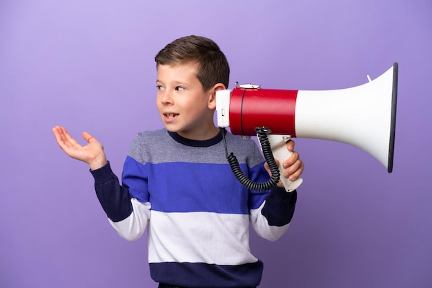 Garotinho isolado no fundo roxo segurando um megafone e com expressão facial de surpresa