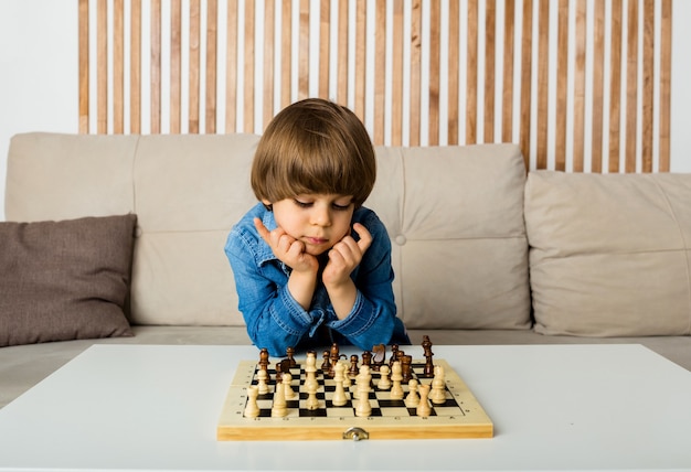 Menino Ruivo Nos óculos Sentado Em Casa E Jogando Xadrez Sozinho. Imagem de  Stock - Imagem de movimento, jogar: 208485515