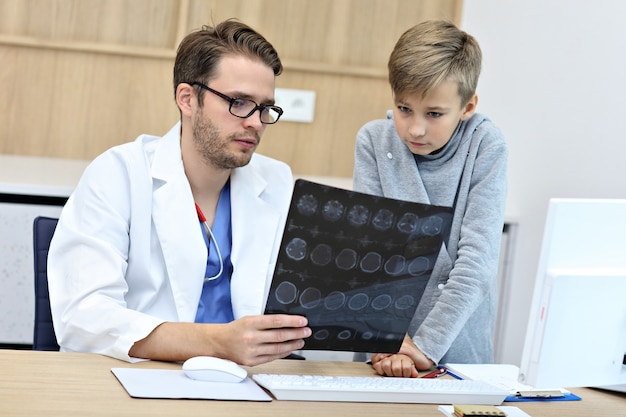 garotinho na clínica sendo examinado pelo pediatra