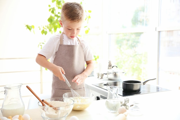 Garotinho na cozinha fazendo massa