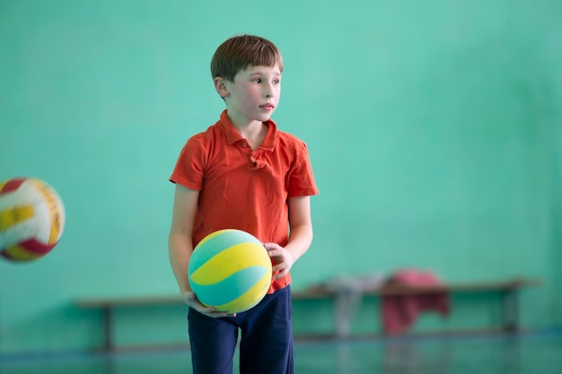 Garotinho no ginásio com uma bola