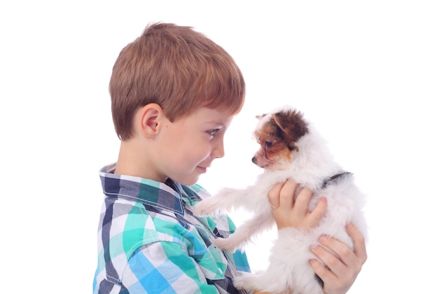 Garotinho olhando com amor para um cachorrinho fofo