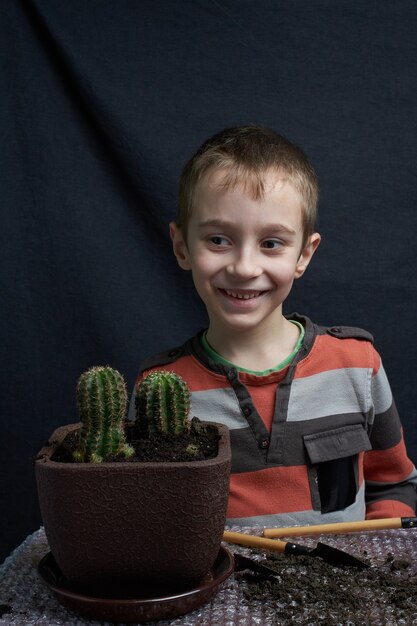 Foto garotinho pousou seu cacto de planta doméstica