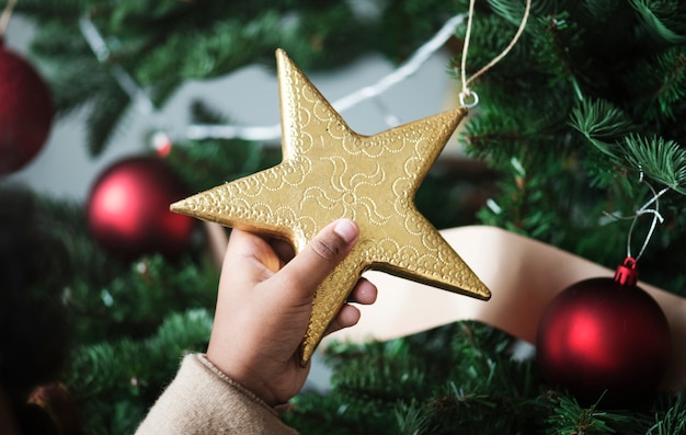 Garotinho segurando uma estrela de Natal