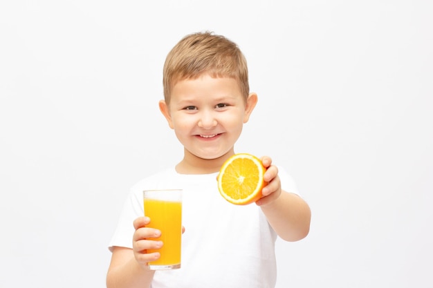 Garotinho tomando um copo de suco de laranja refrescante - isolado no branco