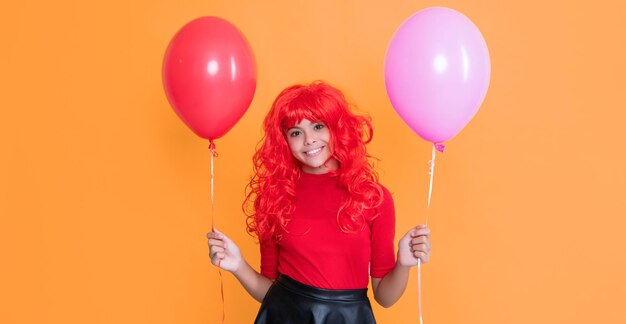 Garoto adolescente alegre com balão de festa em fundo amarelo