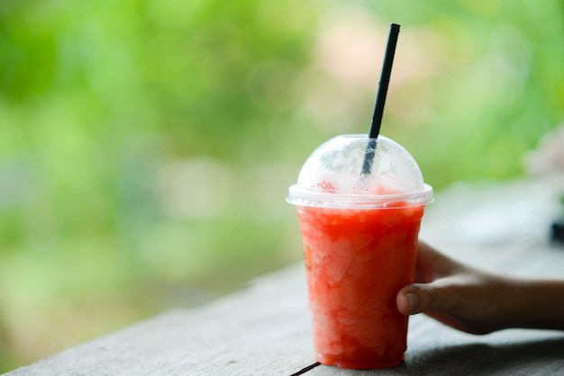 Garoto adolescente bebendo suco de frutas no parque acampando no horário de verão