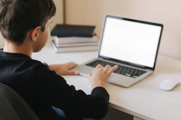 Garoto adolescente estudando no paltip em casa Garoto jogando jogos online em casa estudando em quarentena feliz