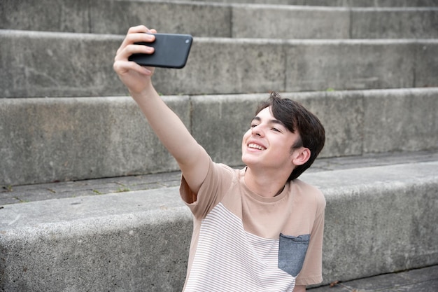 Garoto adolescente sorridente tomando selfie