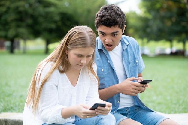 Garoto adolescente surpreso espionando telefone para namorada