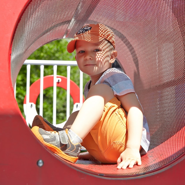 Garoto adorável no playground de verão