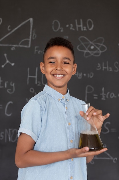 Garoto aprendendo mais sobre química na aula