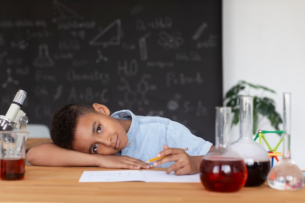 Foto garoto aprendendo mais sobre química na aula