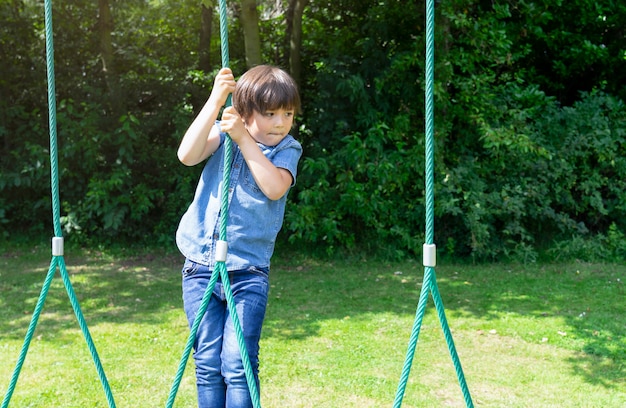 Garoto ativo, segurando o roupão no playground