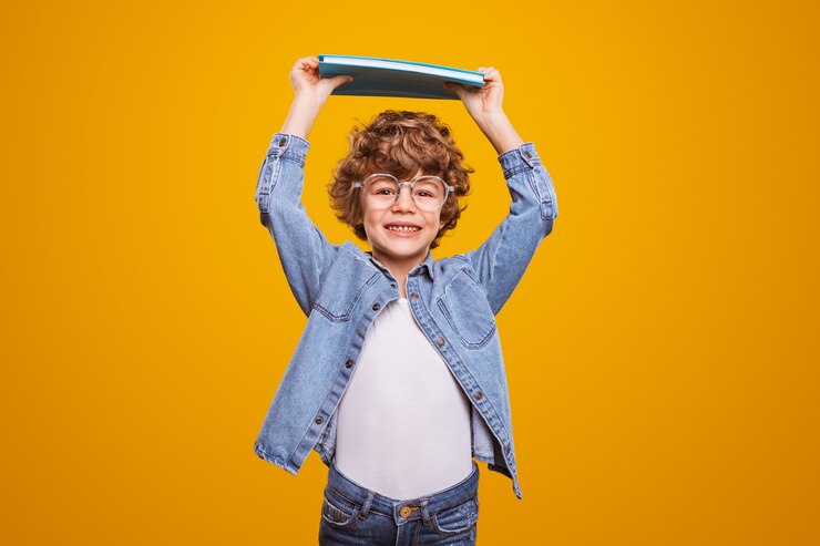Foto garoto bonito com cabelo encaracolado segurando um livro