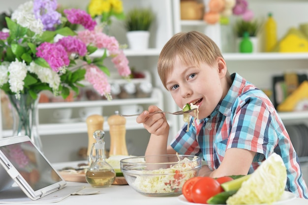 Garoto bonito comendo salada saudável