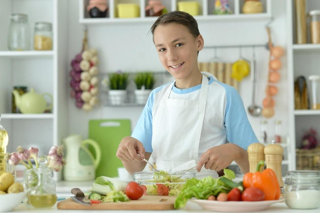 Garoto bonito preparando cozinhar em casa