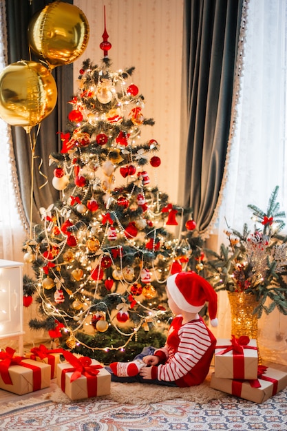 Garoto bonito usando chapéu de Papai Noel