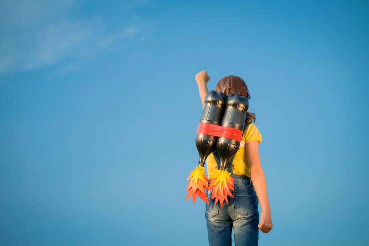 Foto garoto com jet pack finge ser super-herói criança brincando no verão ao ar livre líder de sucesso e conceito de vencedor