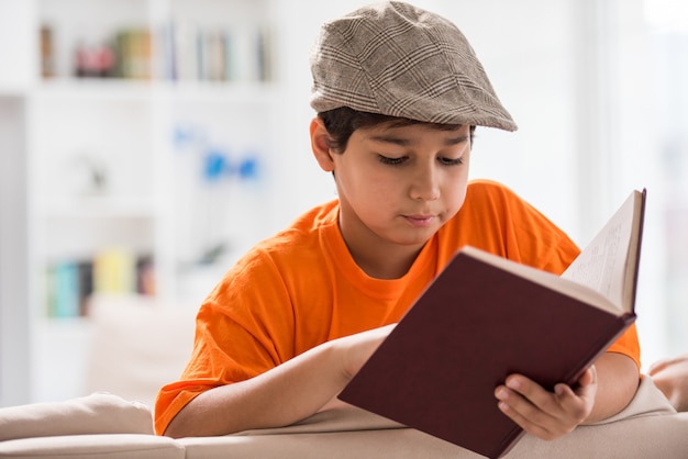 Garoto com livro em casa