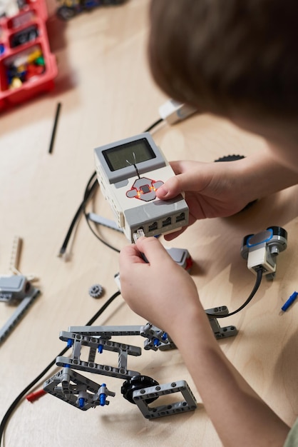 Foto garoto conectando seu robô com computador