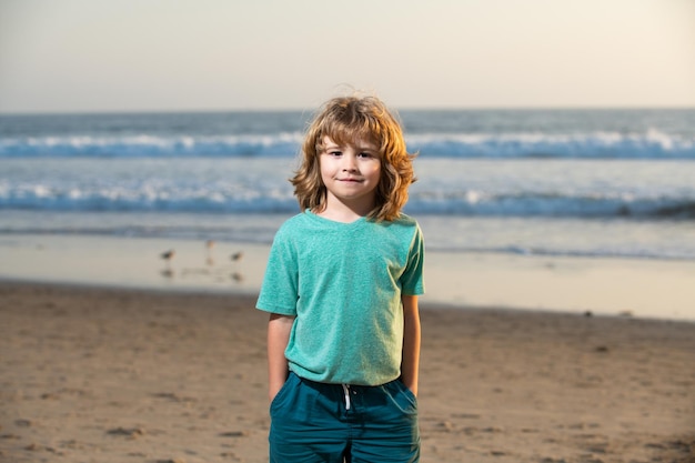 Garoto de camiseta andando na praia de verão