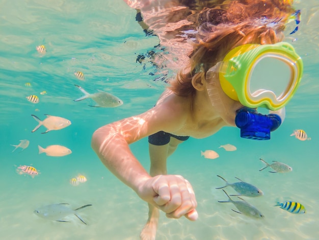 Garoto de estudo da natureza subaquática mergulhando no mar azul claro