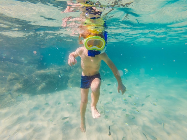 Garoto de estudo da natureza subaquática mergulhando no mar azul claro