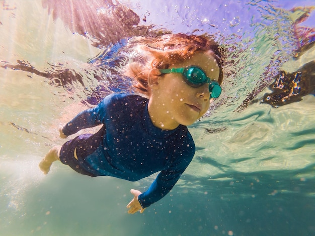 Foto garoto de estudo da natureza subaquática mergulhando no mar azul claro