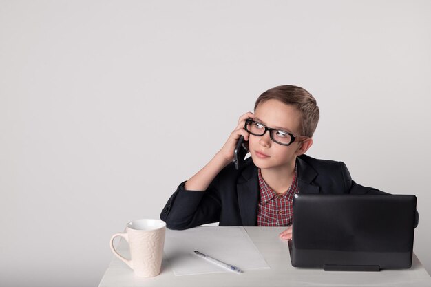 Garoto de negócios falando ao celular no escritório