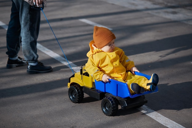 Garoto de um ano anda em um grande caminhão de brinquedo