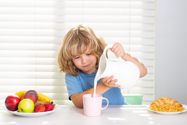 Garoto derramando leite de vacas inteiras em uma escola tomando café da manhã antes do retrato escolar de uma criança adolescente