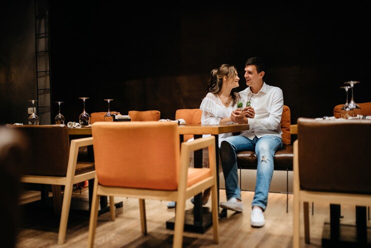 Garoto e garota almoçam em um café e bebem coquetéis