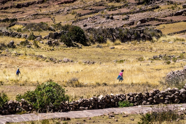 Garoto e garota locais correndo para casa na ilha de taquile, no lago titicaca per