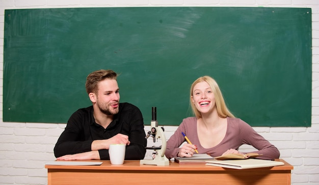 Garoto e garota sentam na sala de aula Estudando na faculdade ou universidade Amigos estudantes estudando universidade Diversão na faculdade Educação moderna Se divertindo na faculdade Alunos despreocupados Aproveitando o tempo na faculdade